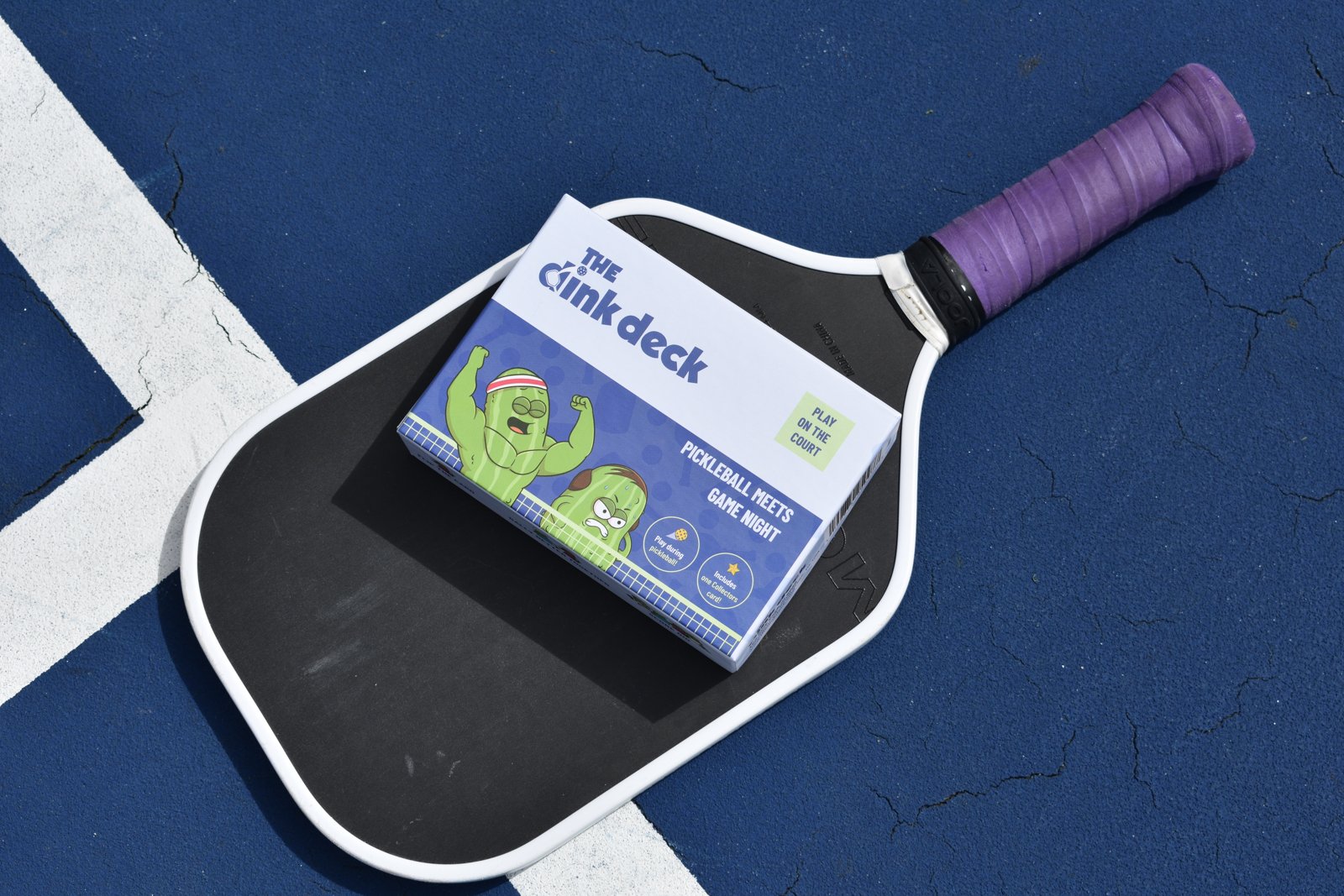 The Dink Deck box on a pickleball paddle