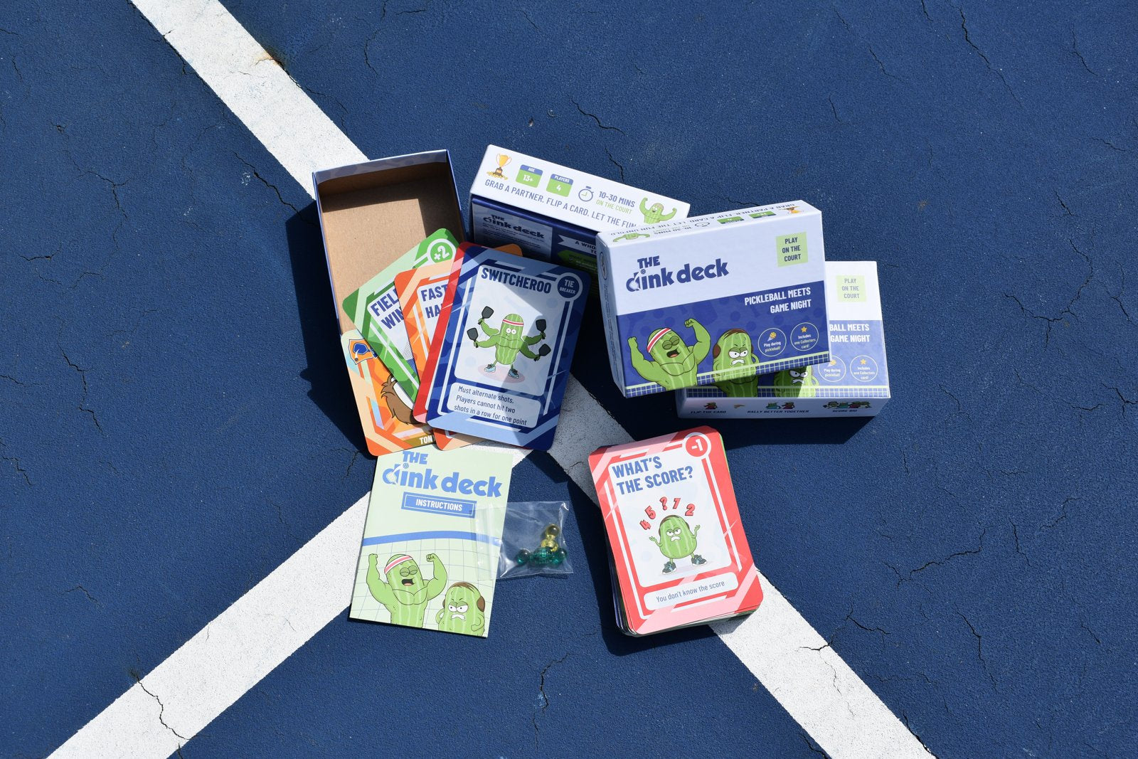 Open Dink Deck box with cards, magnets and instructions on the court